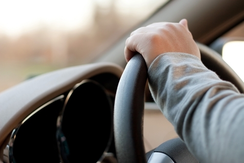 Hand on steering wheel of leased car