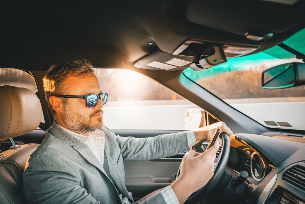 man texting on cell phone while driving
