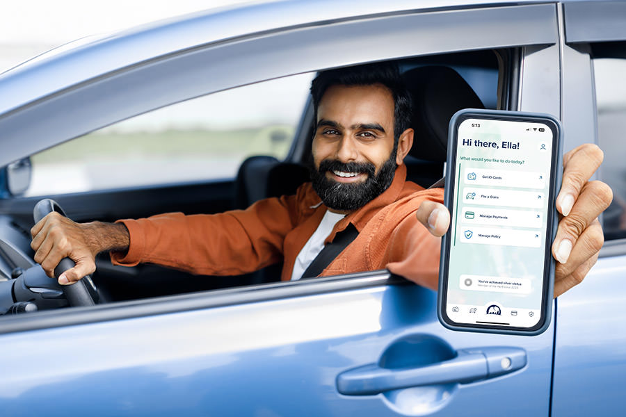 insurance company with elephant Man accessing Elephant Insurace mobile app from a car